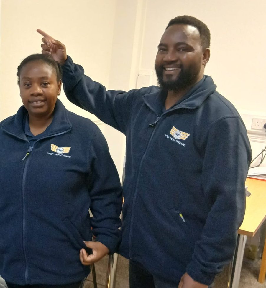 Two YPEP Healthcare staff in navy branded fleeces at the office