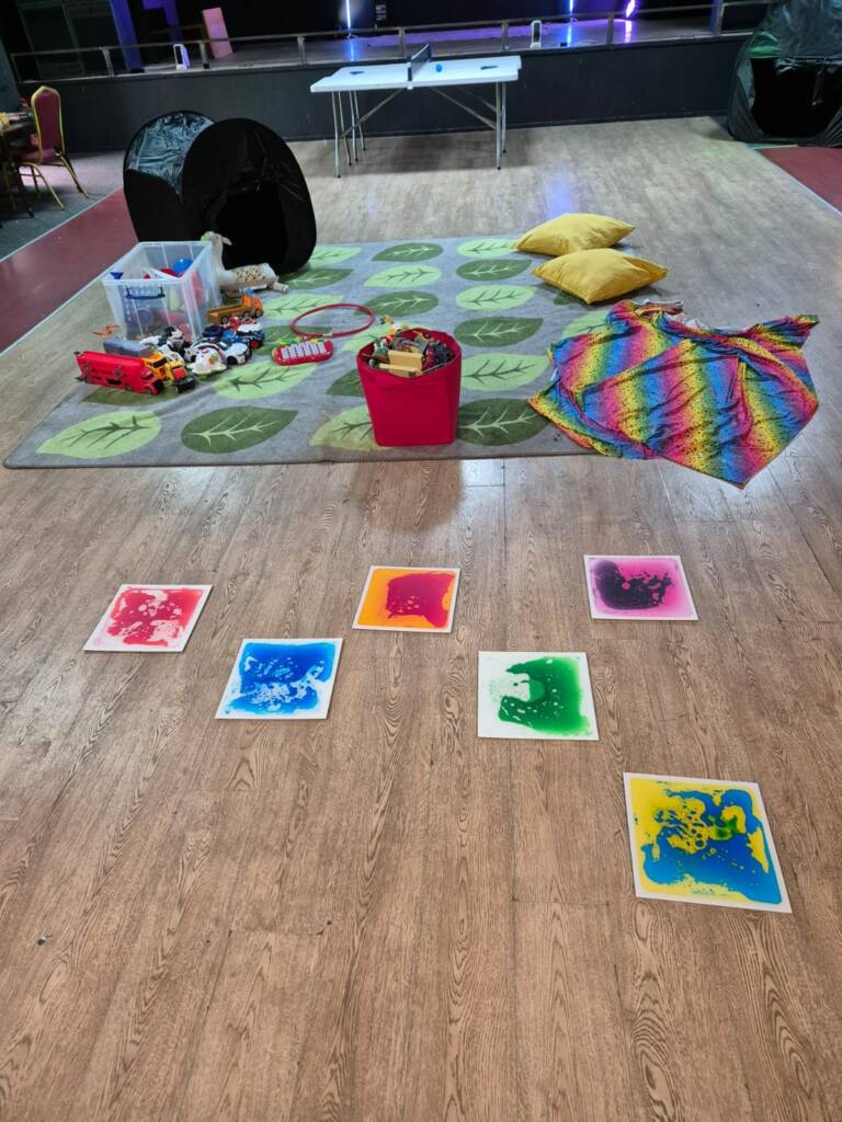 A PlayScheme hall set up for sensory play, with gel floor tiles, cushions, a play tent and toys